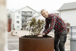 Daniel Backlund fra Växtbygget planter i en stor plantekasse.