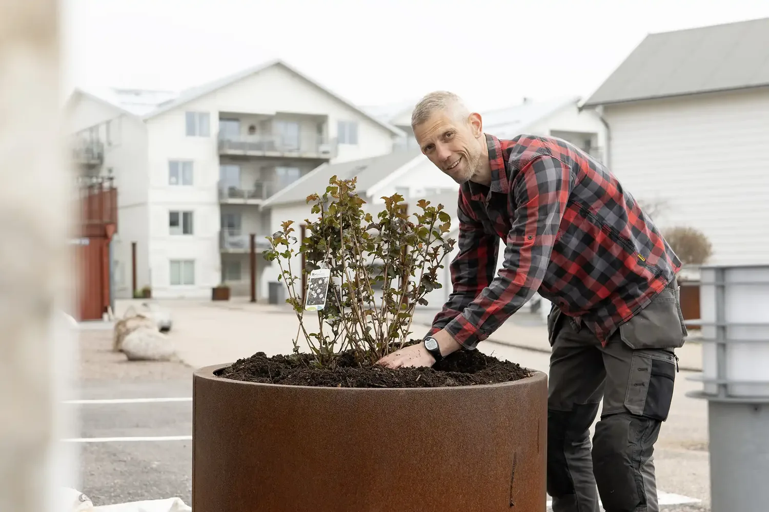 Daniel Backlund fra Växtbygget planter i en stor plantekasse.